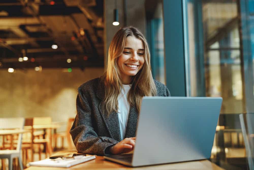 Young professional woman working on her laptop in a cozy cafe