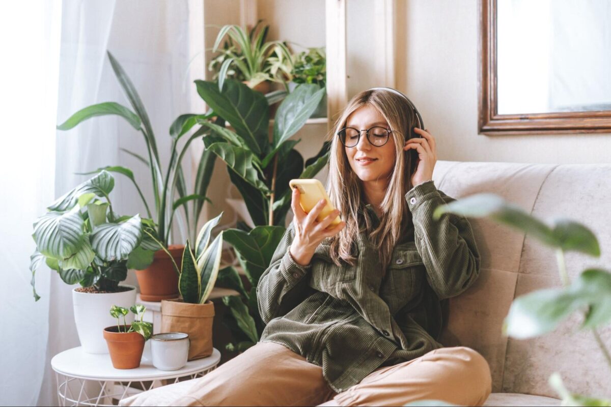 Woman looks at her phone in her furnished apartment