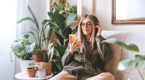 Woman looks at her phone in her furnished apartment