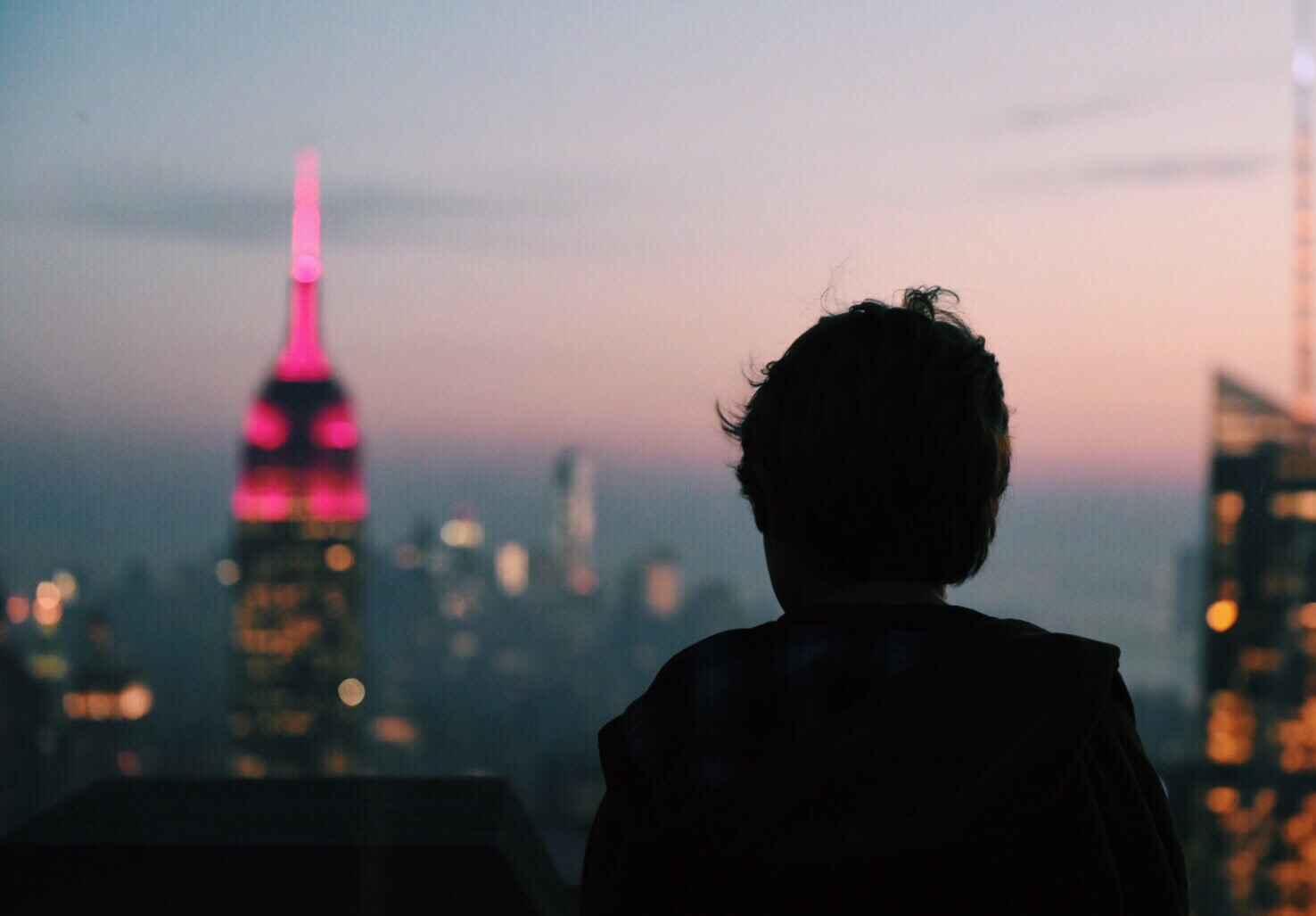A person looks out at the New York City Skyline