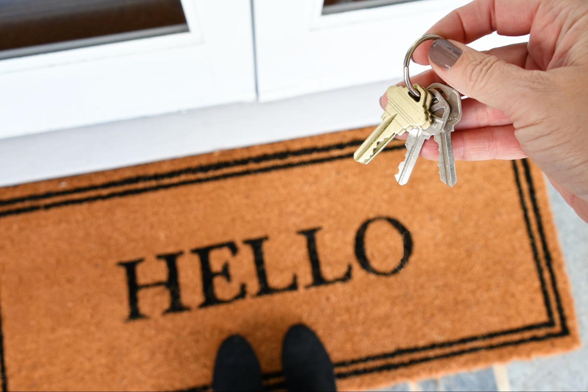Welcome mat that says "Hello" with apartment key.