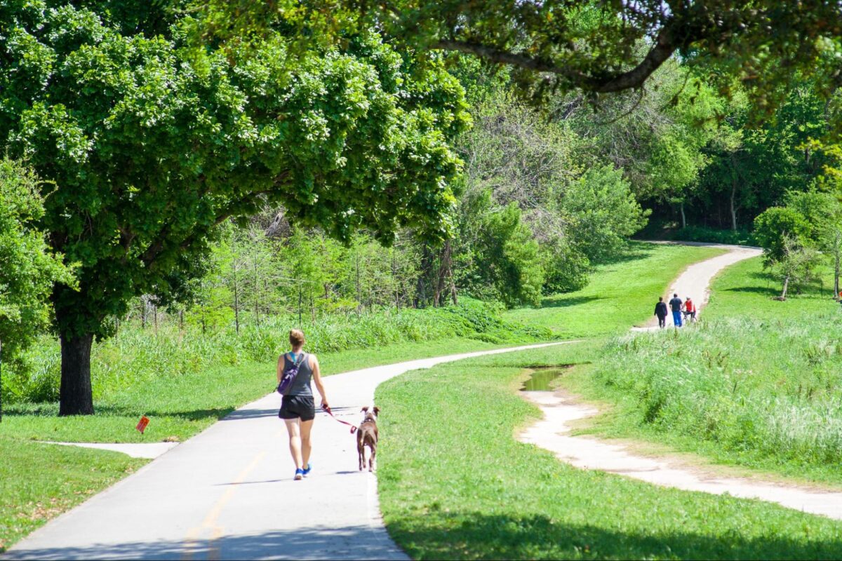 A woman walking her dog on the Buffalo Bayou trails in Houston, Texas