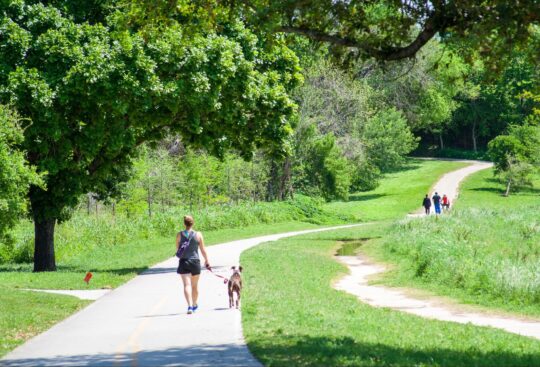 A woman walking her dog on the Buffalo Bayou trails in Houston, Texas