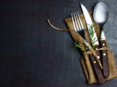 Rustic vintage set of cutlery knife, spoon, fork. Black background.