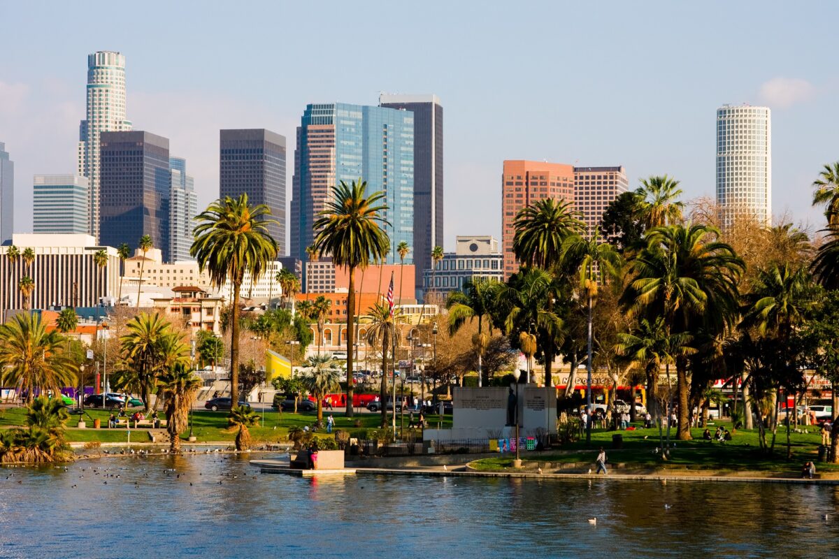 Skyline view of Downtown Los Angeles, including high-rise buildings and palm trees.