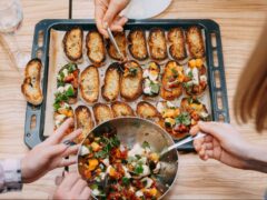 Group makes bruschetta on a table as part of an experience holiday gift