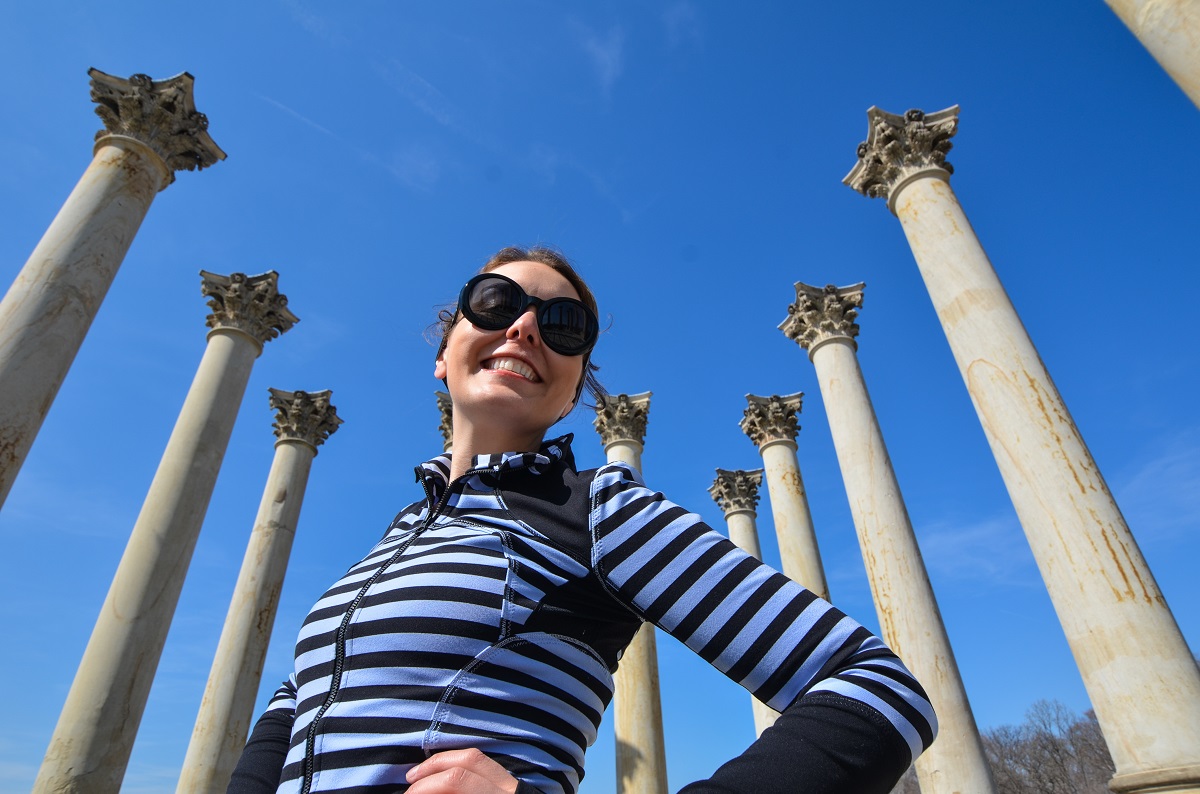 Smiling young woman poses in front of the Capitol Columns at the National Arboretum in Washington, D.C.