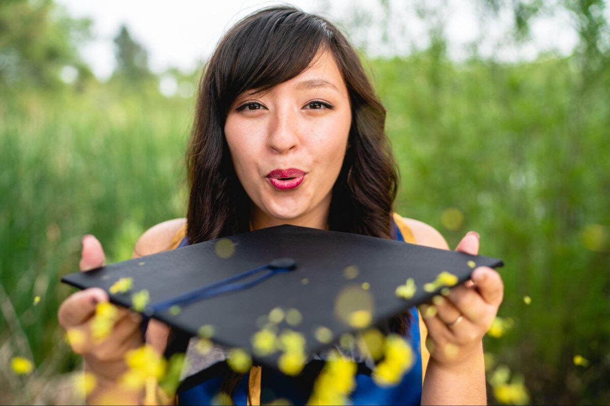 Graduate student blows glitter off her graduation cap.
