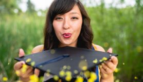 Graduate student blows glitter off her graduation cap.