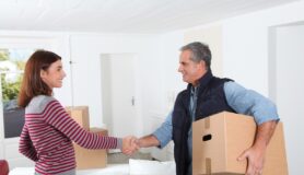 Woman shaking hands with professional mover after giving movers a tip.