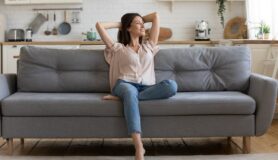 Woman sitting on couch in cozy living room in her apartment.