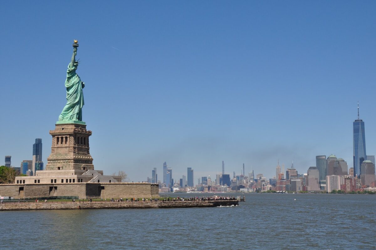 New York City skyline cityscape with Statue of liberty over the Hudson River.