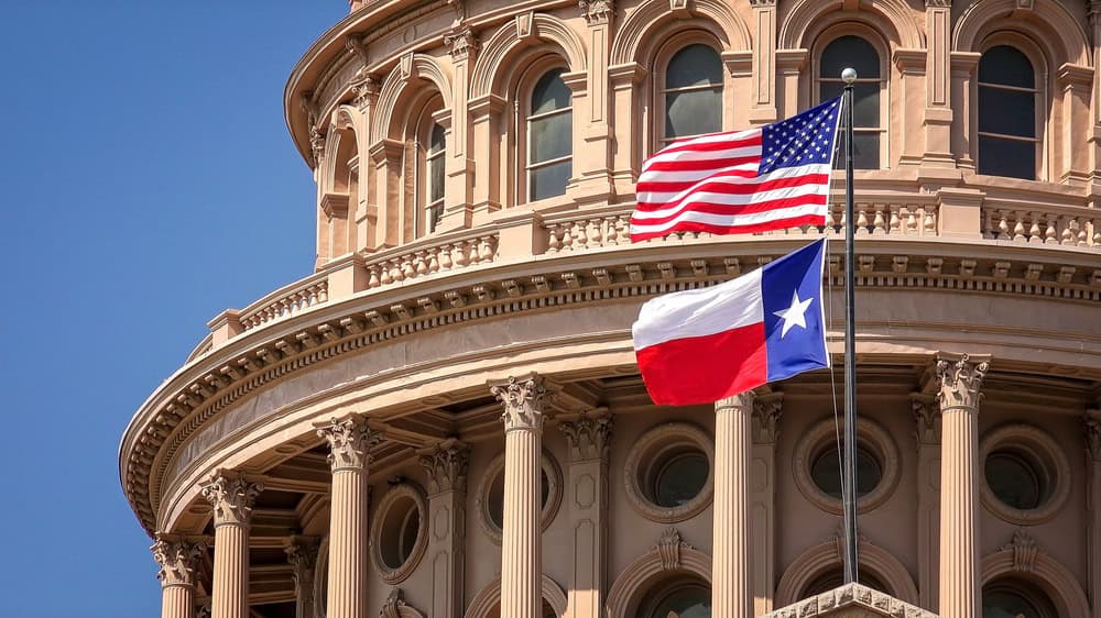 American and Texas flags on the Texas State Capitol building in Austin, TX