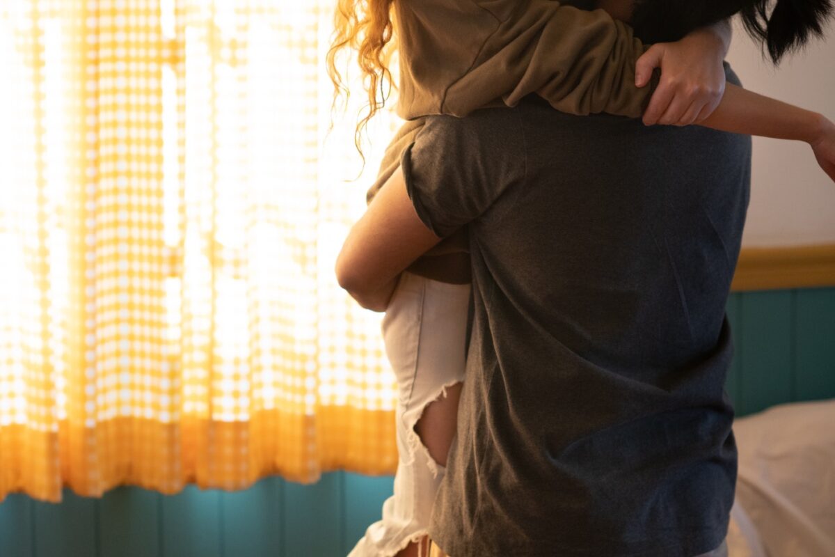 Couple embraces in their apartment after moving in together.