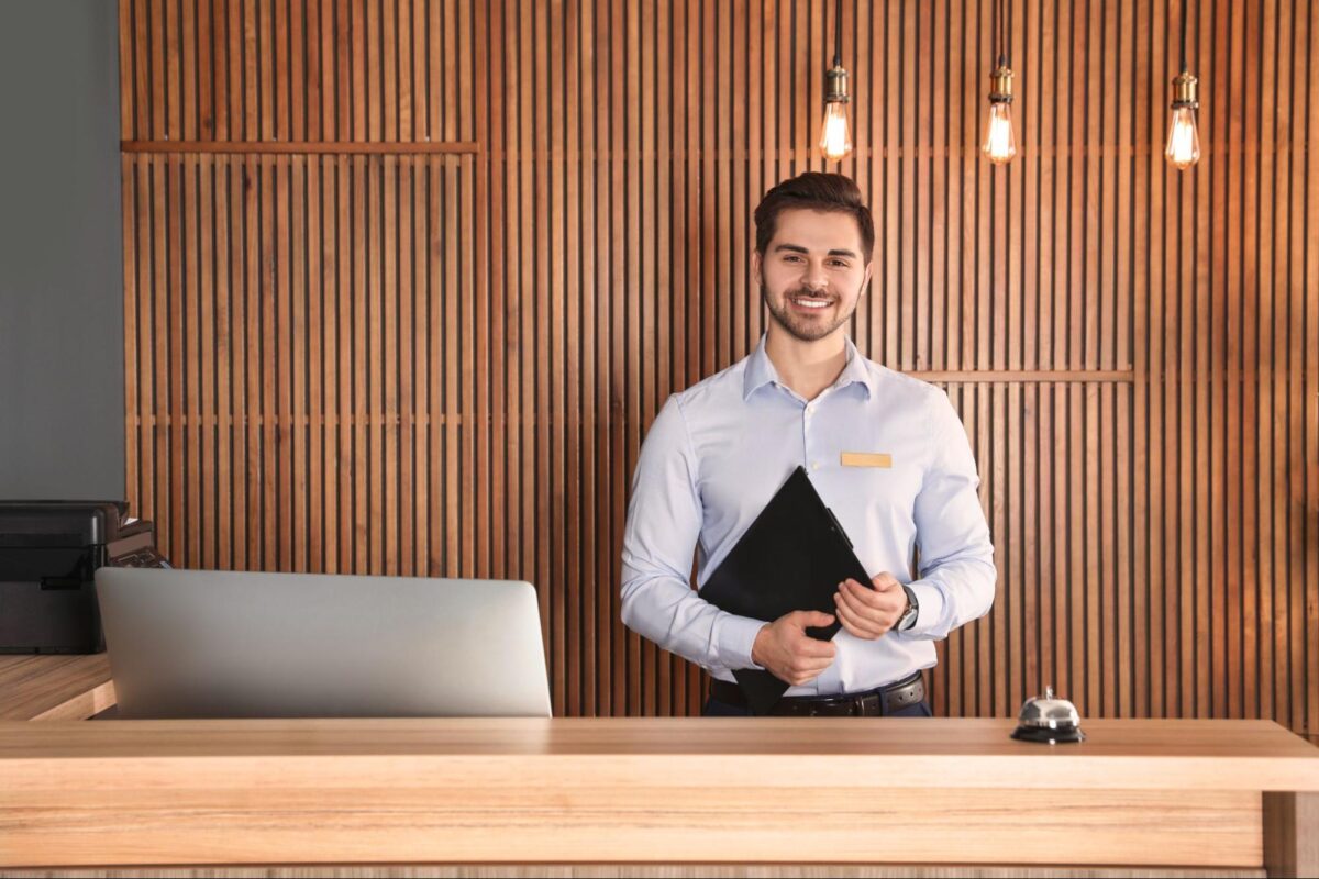 Concierge stands behind a desk in an apartment building.