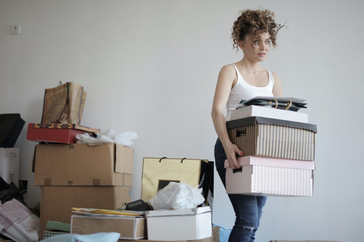 Woman moves boxes as part of an apartment move.
