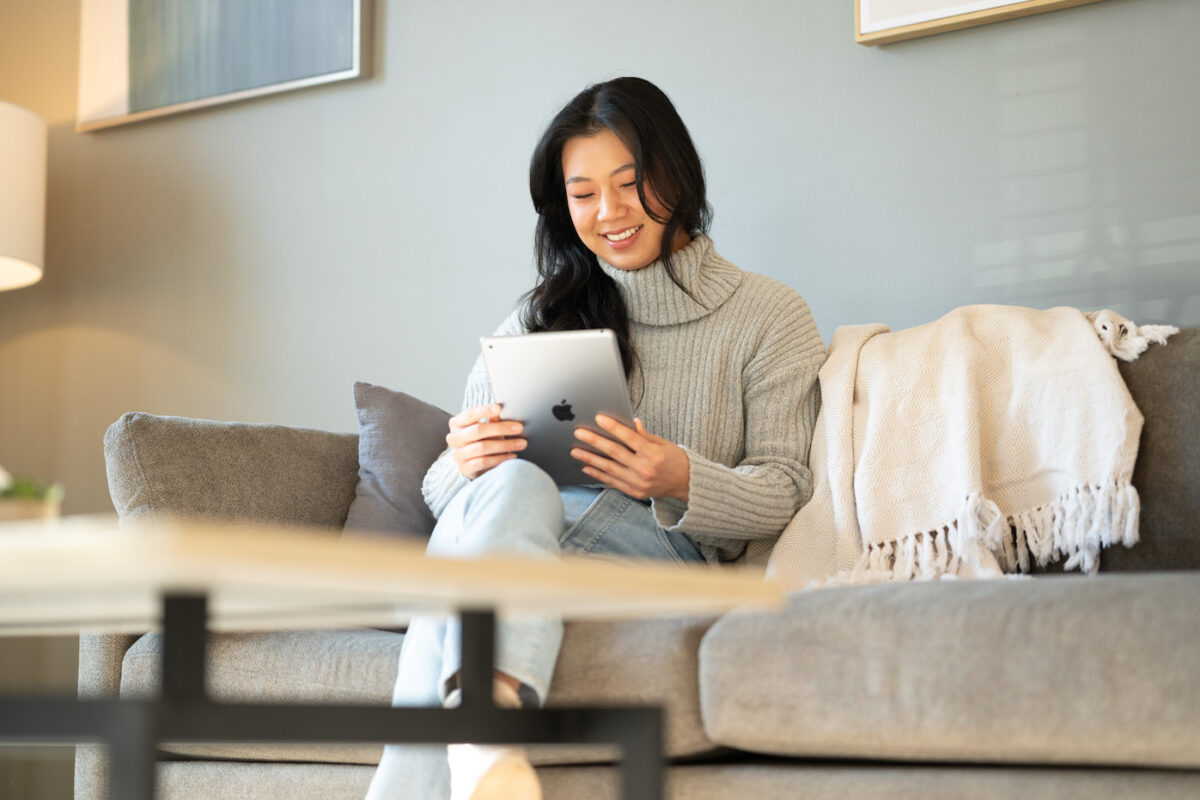 Woman looks at her iPad in her rented apartment.