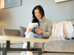 Woman looks at her iPad in her rented apartment.