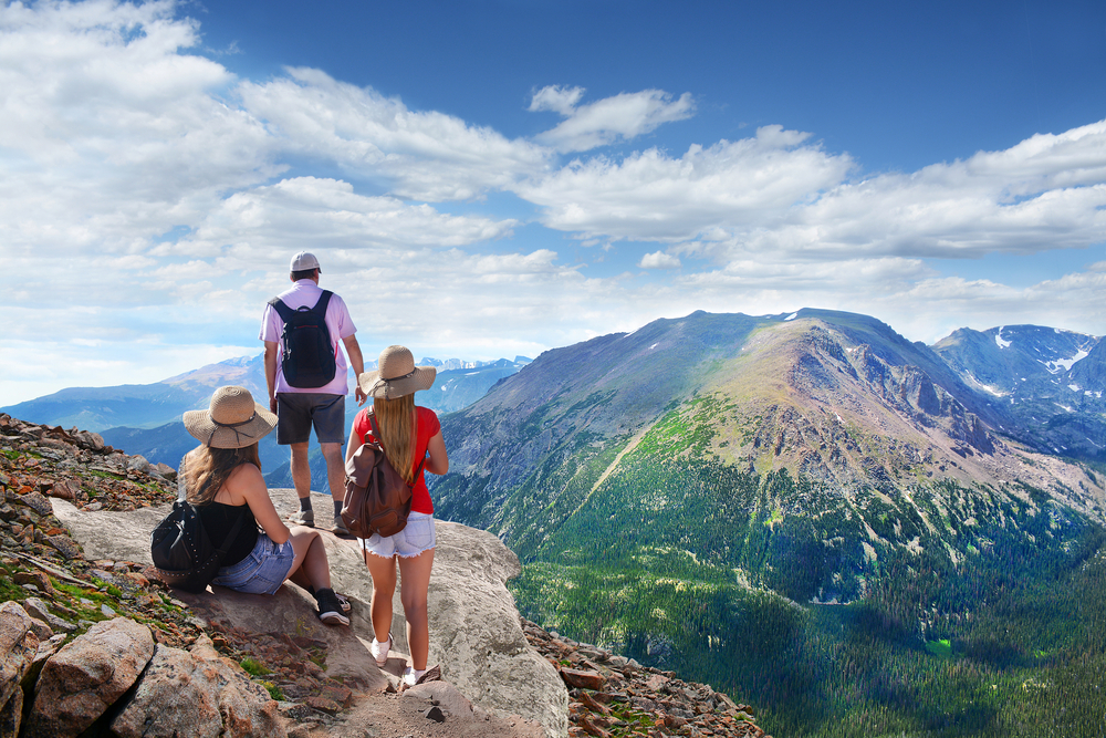People standing on a peak in Rocky Mountain National Park, one of the best day trips from Denver.