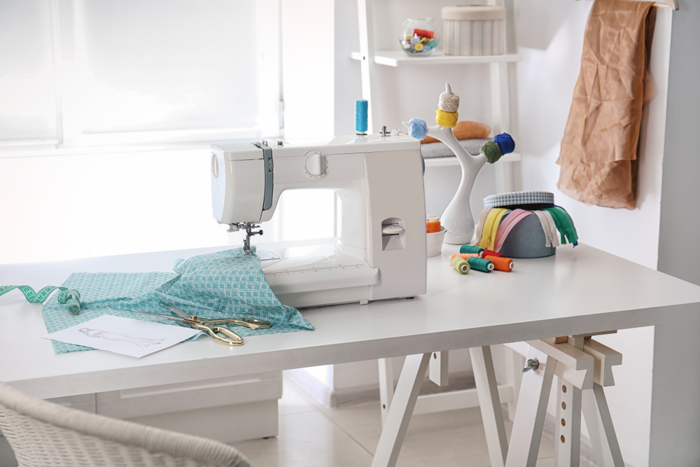 Sewing machine with fabric on table in tailor workshop