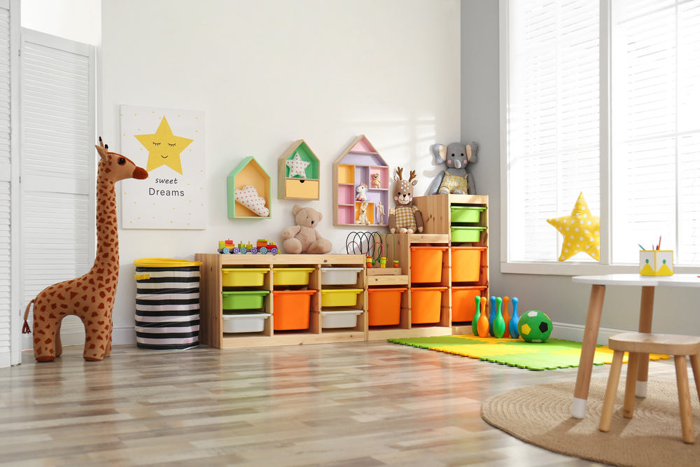 Stylish playroom interior with shelving unit and different soft toys