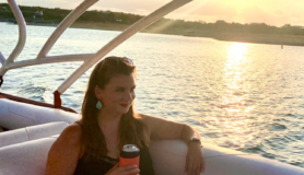 Landing member Jess Goudreault sits on a boat on Lake Travis in Austin, Texas.