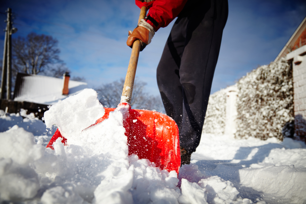 Man with snow shovel cleans sidewalks in winter. Winter time. Latvia. Europe. 