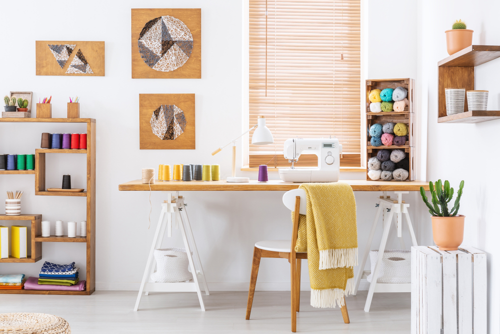 Real photo of a colorful room interior with a desk, sewing machine and threads