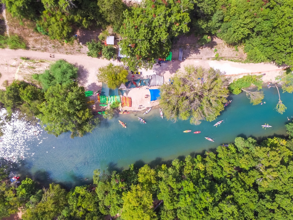 Aerial view Barton Creek in Greenbelt area, a 7.9 miles long with 809 acres begins at Zilker Park. It has sheer limestone cliff, lush trees. People swimming , canoe and kayak in cold natural water.