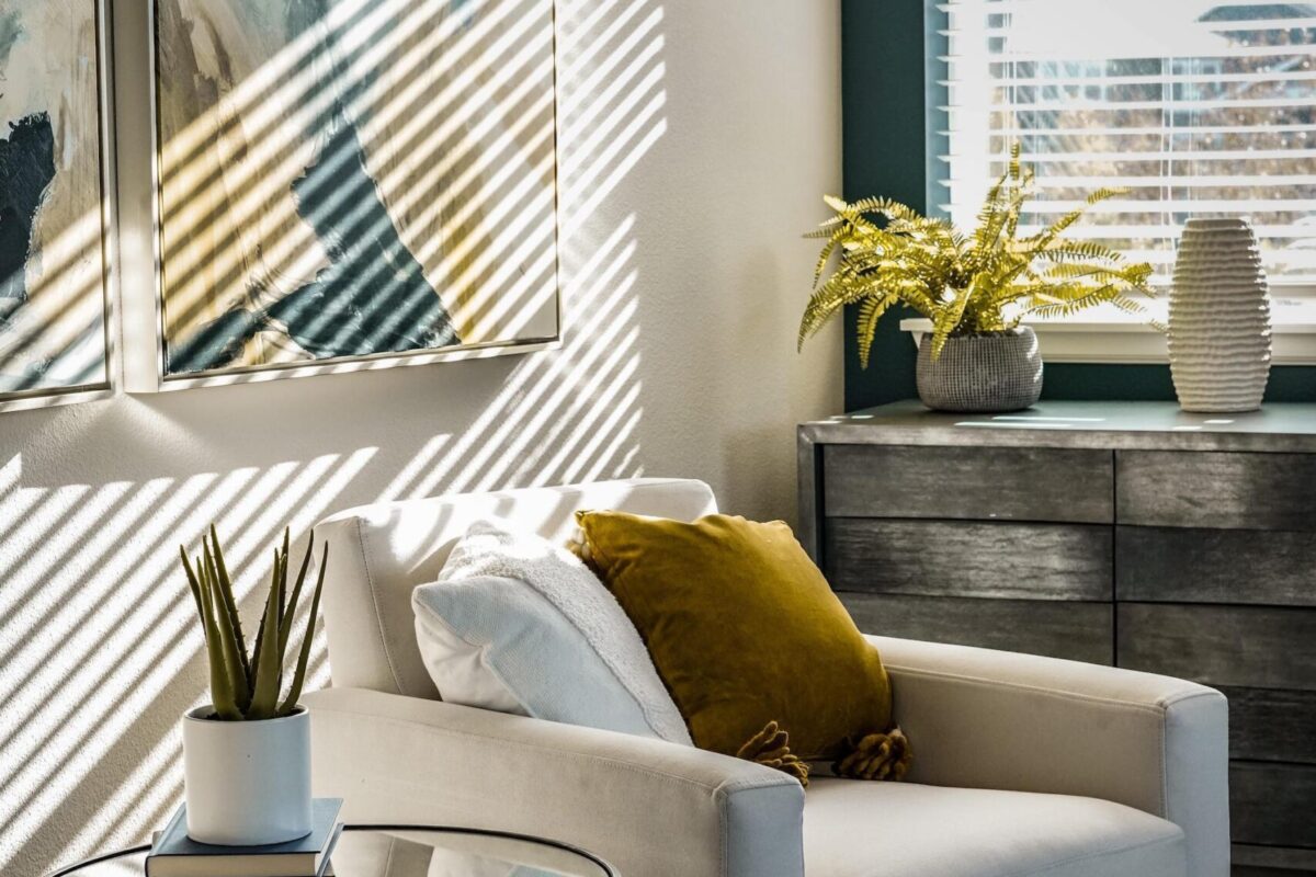 A sunny apartment features a bright window and a chair.