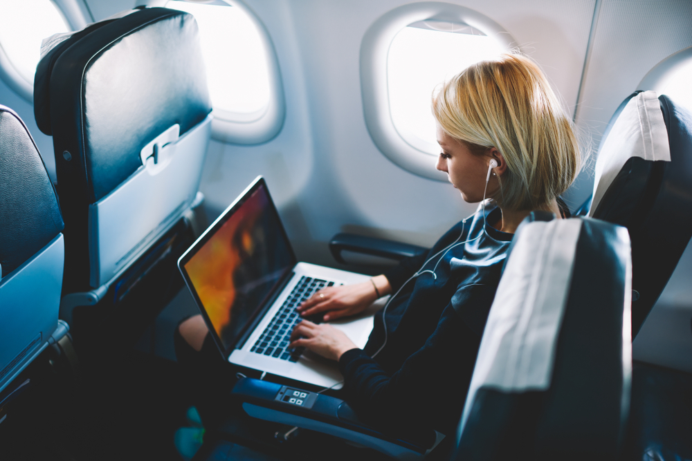 Young woman working from her laptop on an airplane