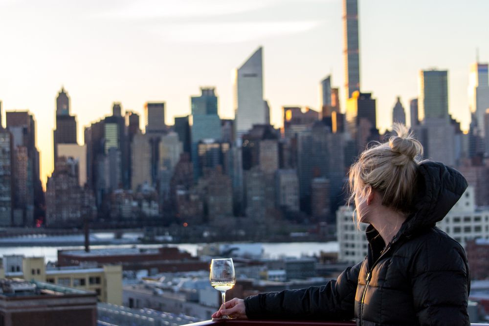 Girl drinking wine in New York City at sunset - rooftop bar