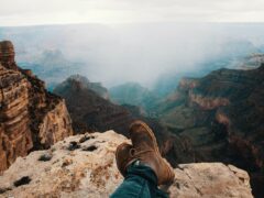 Hiker sits on the edge of a cliff at the Grand Canyon, which features one of the best hiking trails in the U.S.