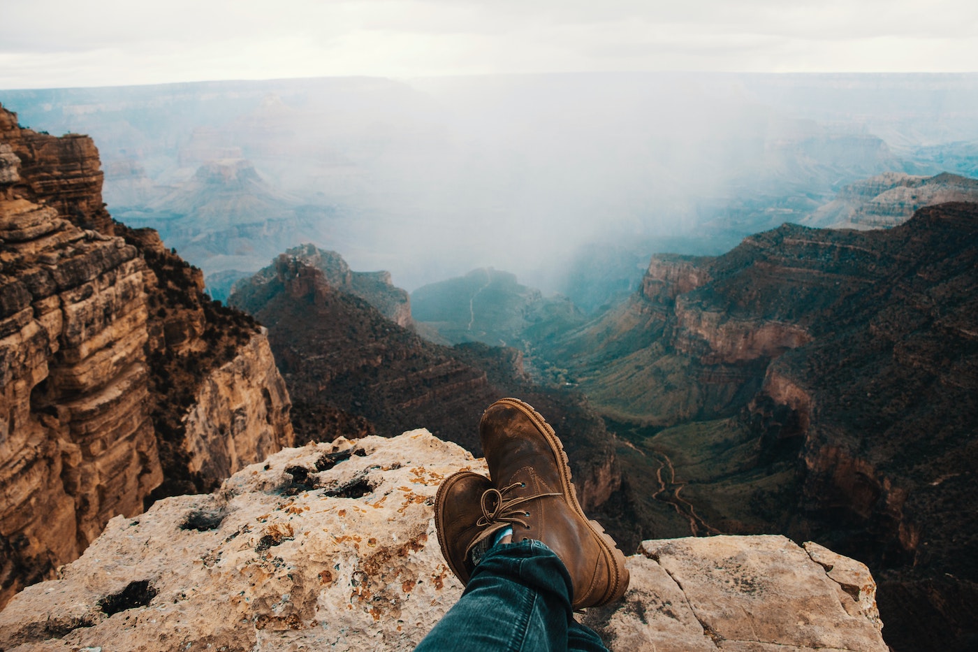 Hiker sits on the edge of a cliff at the Grand Canyon, which features one of the best hiking trails in the U.S.
