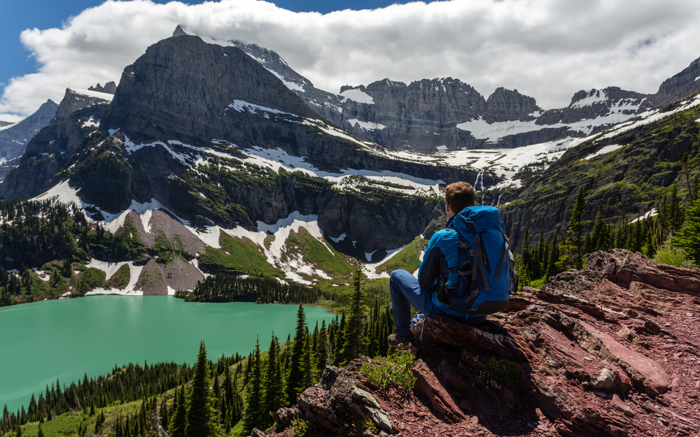 Hiker in glacier national park enjoying the view of Grinnell lake