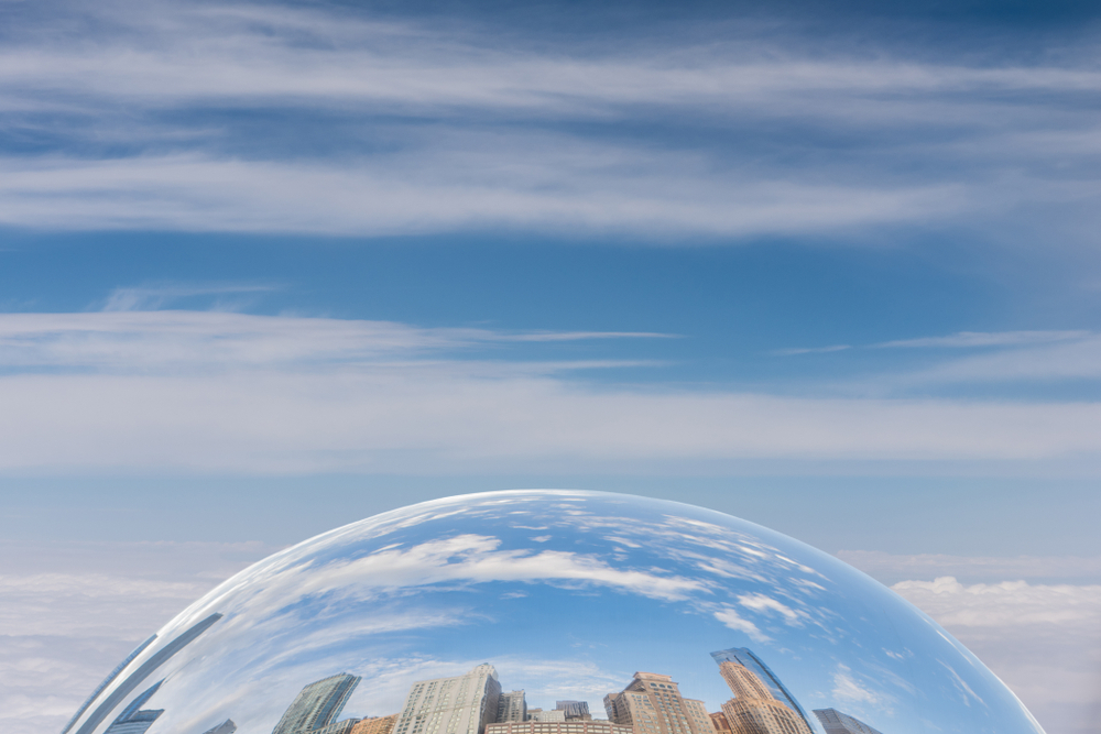 Downtown skyscrapers reflected in the mirror surface of The Bean sculpture in Millennium Park in Chicago, Illinois. 