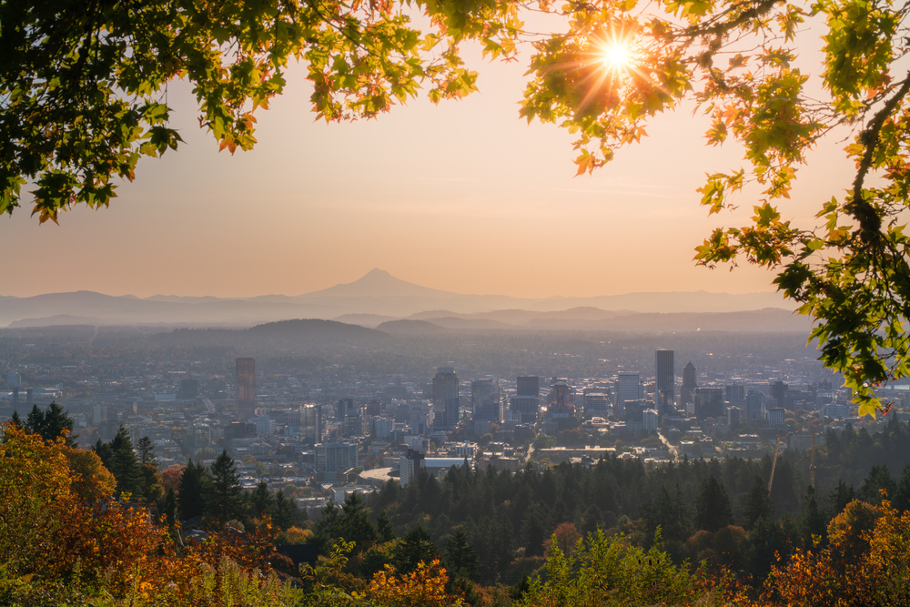 Portland Oregon Downtown in distance and Mt Hood with sunshine behind autumn foliage