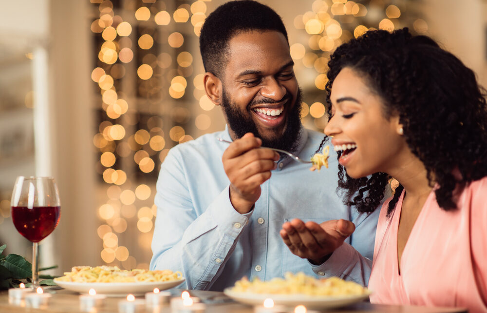 Couple smiling and eating food on a date night in Charlotte, North Carolina.