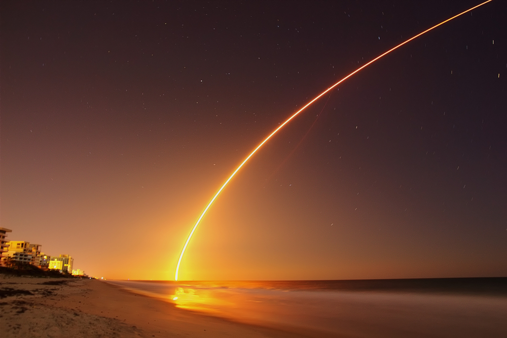 Space rocket lunch at the Atlantic Ocean shore in Florida at night.