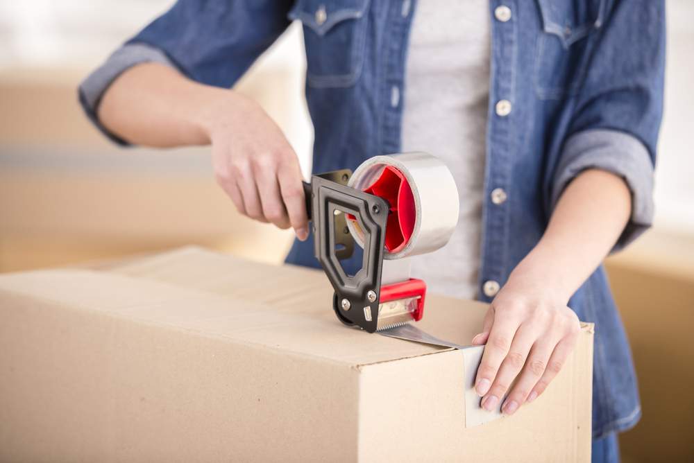 The young happy woman packing boxes. Moving, purchase of new habitation.