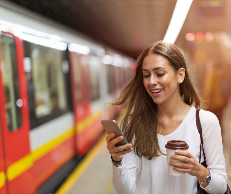 Woman waiting for metro train in New York City, one of the best cities for public transportation.