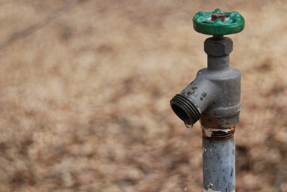 A dripping spigot on the ranch in California. Drought conditions. Extreme measures necessary. Depleted water resources.