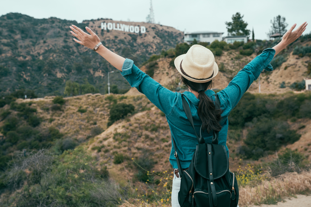 asian woman backpacker love freedom carefree hugging nature while hiking in hollywood hills enjoy fresh air. young girl traveler open arms raising standing on mountain sightseeing view of spring. asian woman backpacker love freedom carefree hugging nature while hiking in hollywood hills enjoy fresh air. young girl traveler open arms raising standing on mountain sightseeing view of spring.
