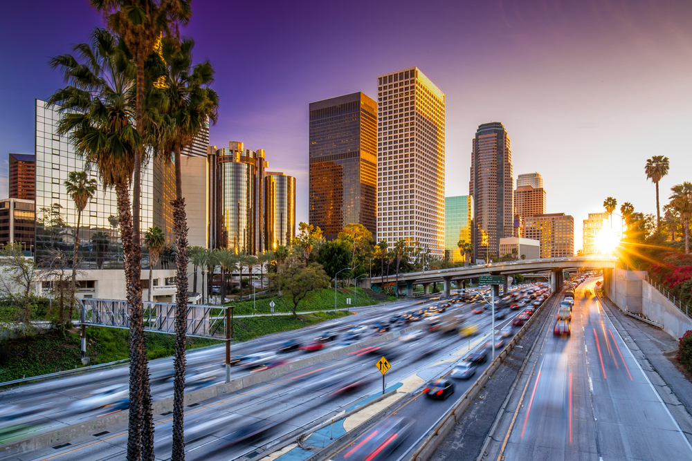Los Angeles downtown buildings and highway car traffic at sunset
