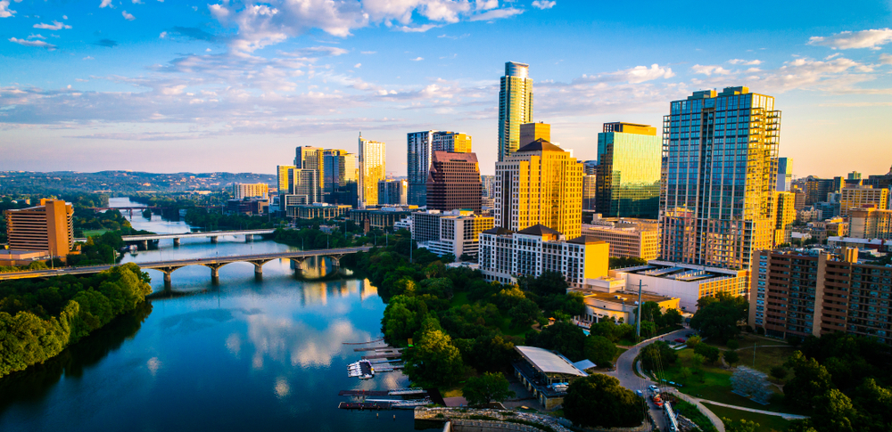 Panoramic sunrise aerial drone view over Lady Bird Lake in Austin Texas the capital city glowing under Morning golden hour sunrise