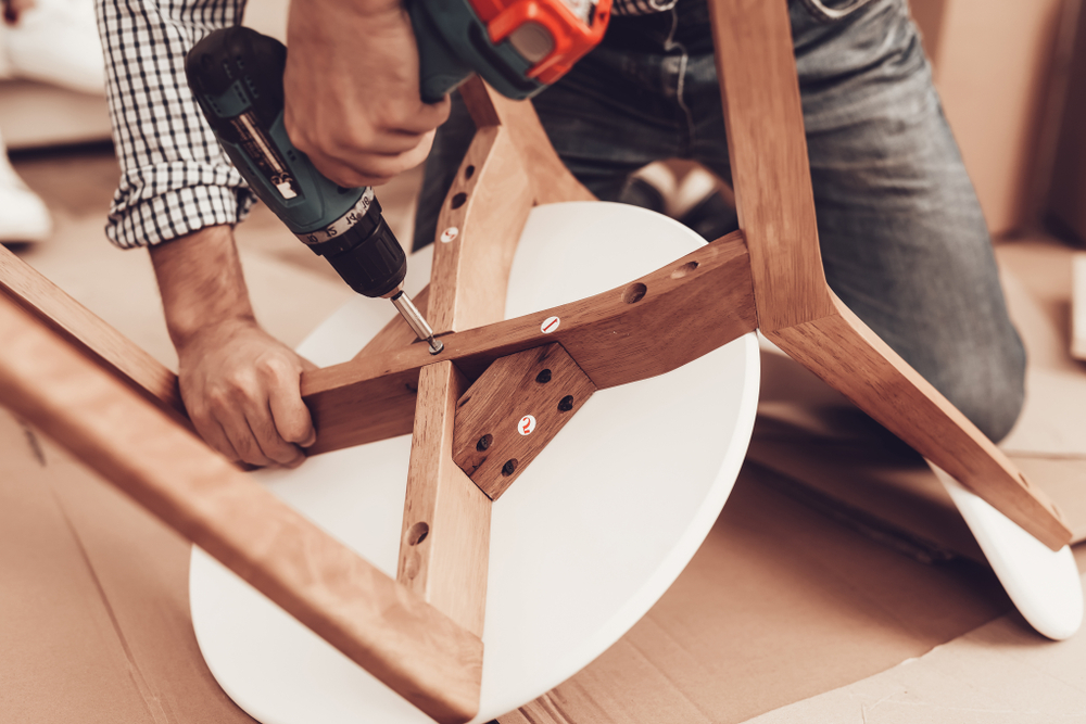 Assemble Furniture. Man Repairing Chair. Man Collects Chair. Furniture Assembler with Drill. Woman on Sofa with Laptop. Bright Interior. Craftsman with Tools Repairs Chair. Furniture Repair. Assemble Furniture. Man Repairing Chair. Man Collects Chair. Furniture Assembler with Drill. Woman on Sofa with Laptop. Bright Interior. Craftsman with Tools Repairs Chair. Furniture Repair.