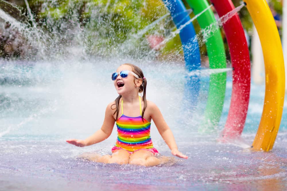 Kids play in aqua park. Children at water playground of tropical amusement park. Little girl at swimming pool. Swim wear for young kid. Kids play in aqua park. Children at water playground of tropical amusement park. Little girl at swimming pool. Swim wear for young kid.