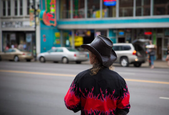 Person wearing a cowboy hat, standing on Lower Broadway in Nashville, Tennessee.
