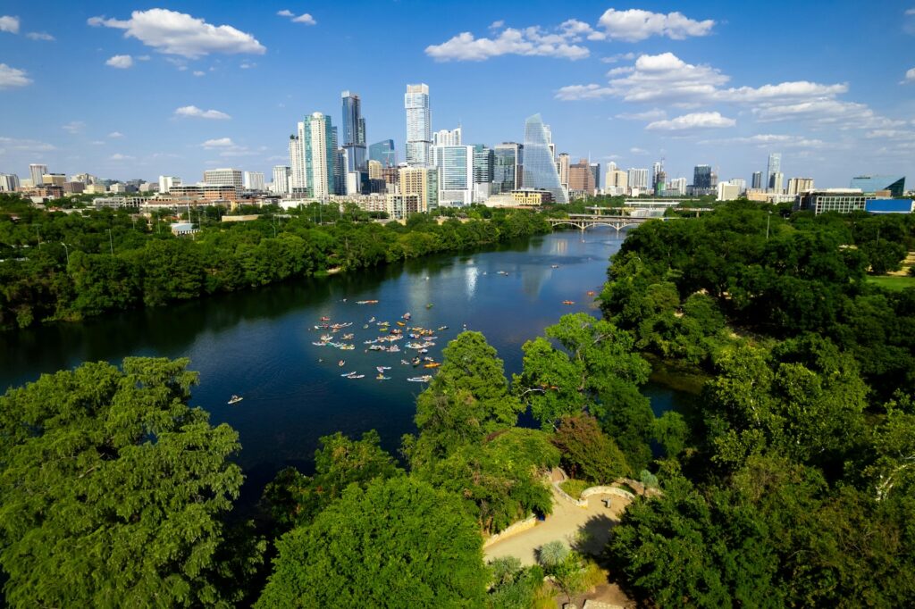 Aerial view of Zilker Park with the downtown Austin, Texas city skyline in the background.