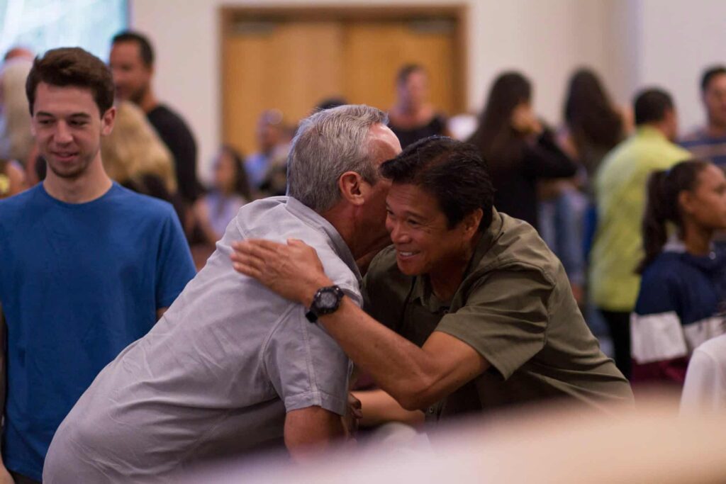 Two men hugging each other.